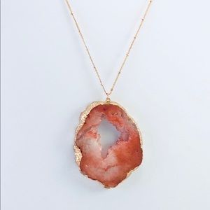 Long geode pendant on gold chain.